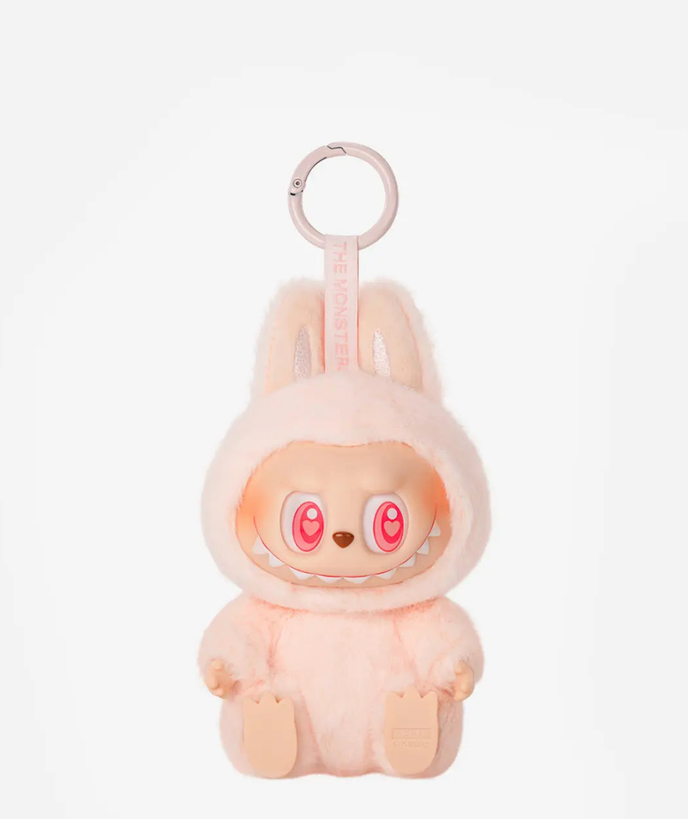 Dada, the peach pink Labubu Have a Seat figure with heart eyes, on a pink keyring