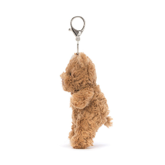 Jellycat Bartholomew Bear plush bag charm from the side, showing its small tail and the clasp