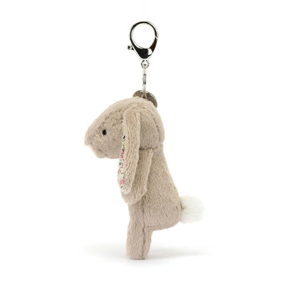 Jellycat Blossom Beige Bunny plush bag charm from the side, showing its white fluffy tail and the clasp