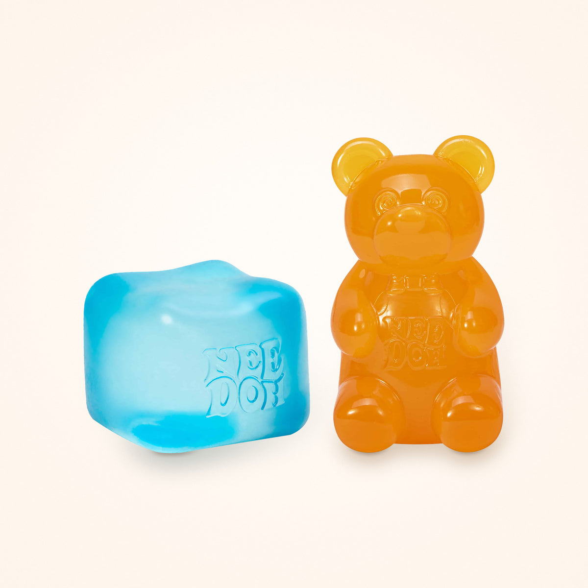 Squishy Gift Box Duo: a blue NeeDoh Nice Cube next to a orange NeeDoh Gummy Bear, shown to scale on a cream background