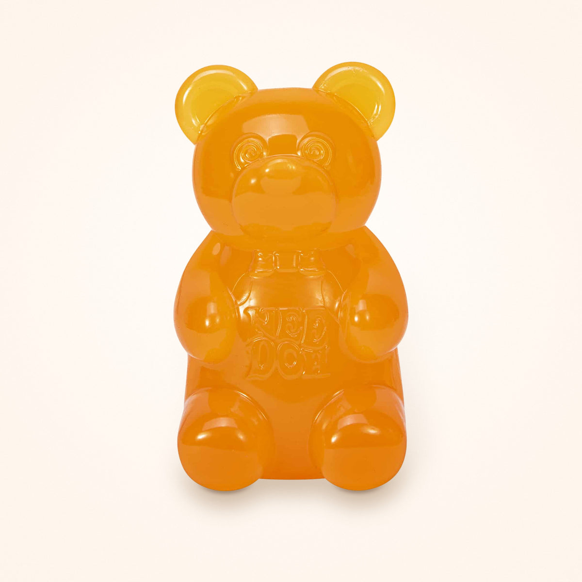 Orange NeeDoh Gummy Bear squishy on a cream background