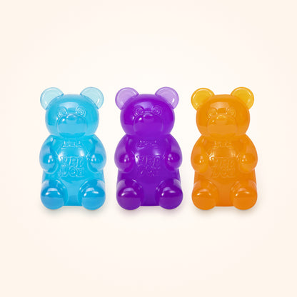 Squishy Stocking Stuffer: three NeeDoh Gummy Bears in blue, purple and orange, shown to scale on a cream background