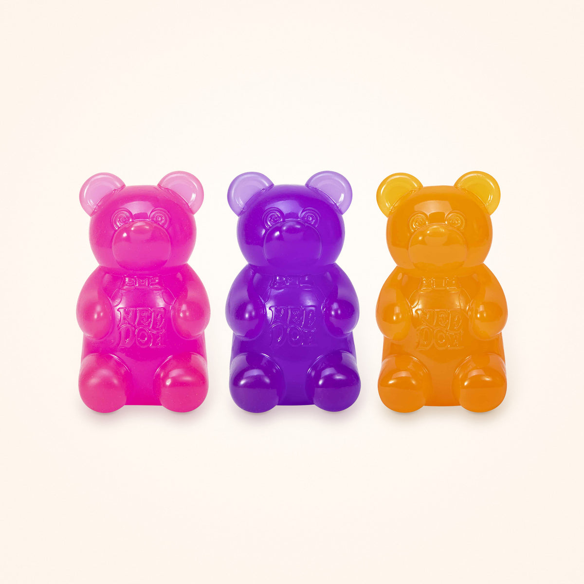 Squishy Stocking Stuffer: three NeeDoh Gummy Bears in pink, purple and orange, shown to scale on a cream background