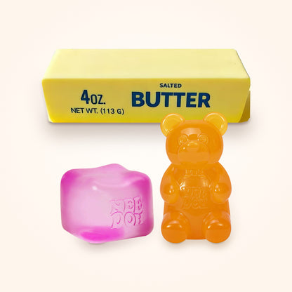 Squishy Gift Box Trio: a pink NeeDoh Nice Cube and a orange NeeDoh Gummy Bear in front of a Mini Butter Squishy, shown to scale on a cream background